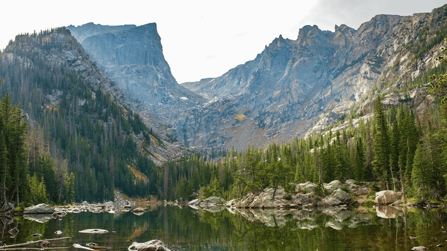 Aerial view of Grand Lake ringed by pine forest and alpine peaks